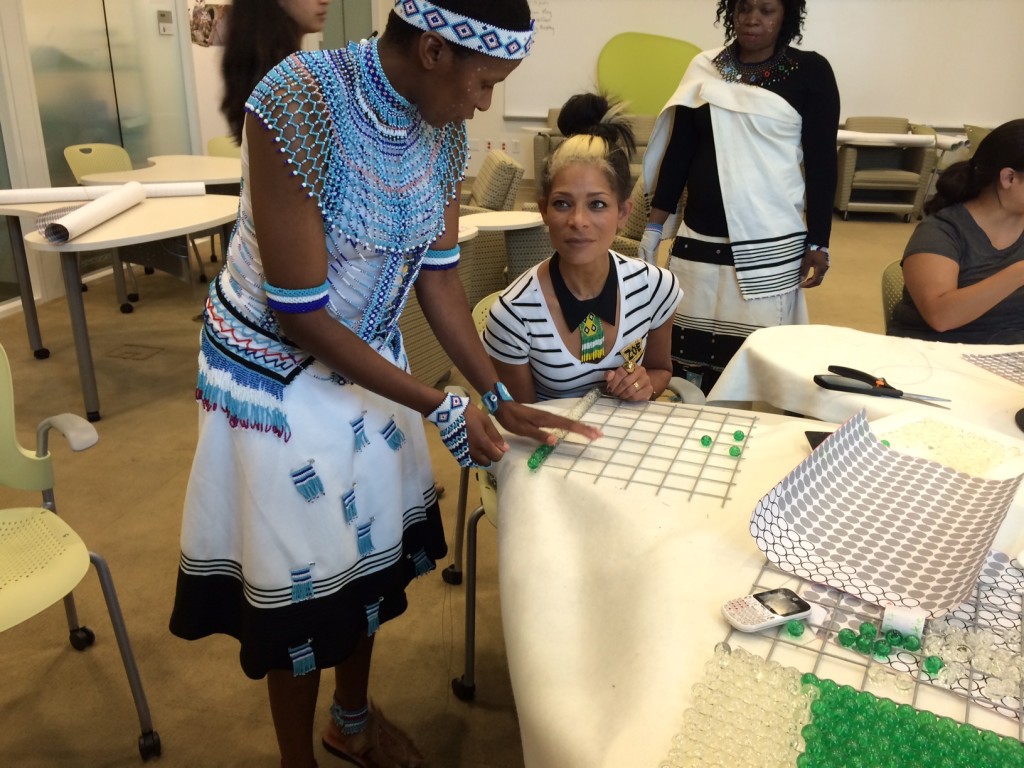 Zoliswa Mkangaye (left) gives beading tips to volunteer Zoe Jackson. Photo by Bulelwa Bam.